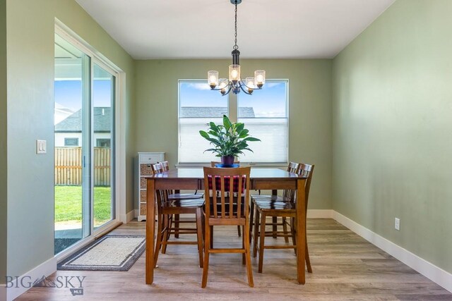 dining room with baseboards, an inviting chandelier, and wood finished floors