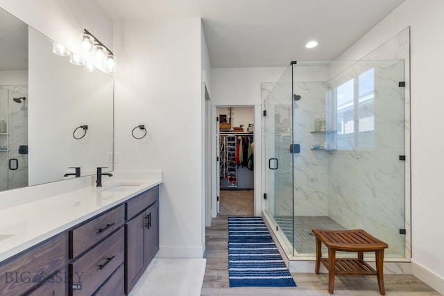 1508 Deadwood Loop, Belgrade, MT 59714 - bathroom featuring a stall shower, double vanity, baseboards, a spacious closet, and recessed lighting