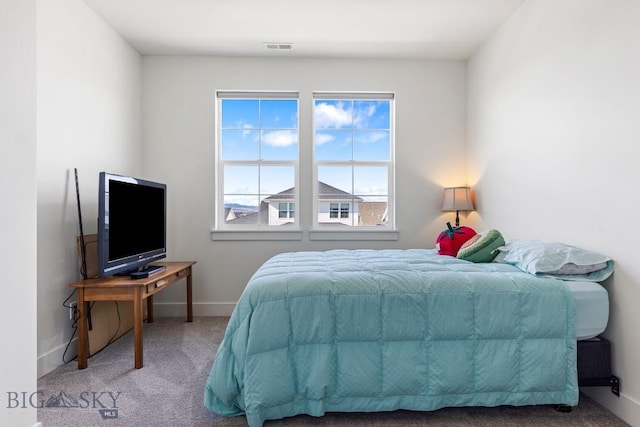 bedroom with baseboards, visible vents, and carpet