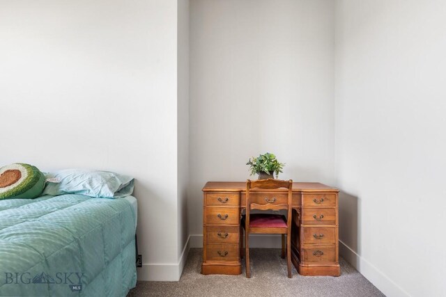 bedroom featuring light colored carpet and baseboards