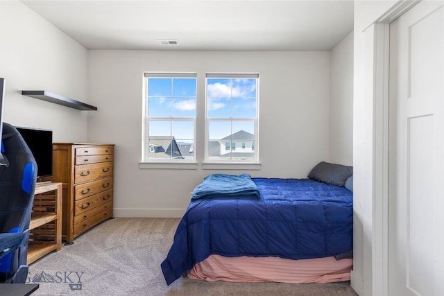 carpeted bedroom featuring visible vents and baseboards