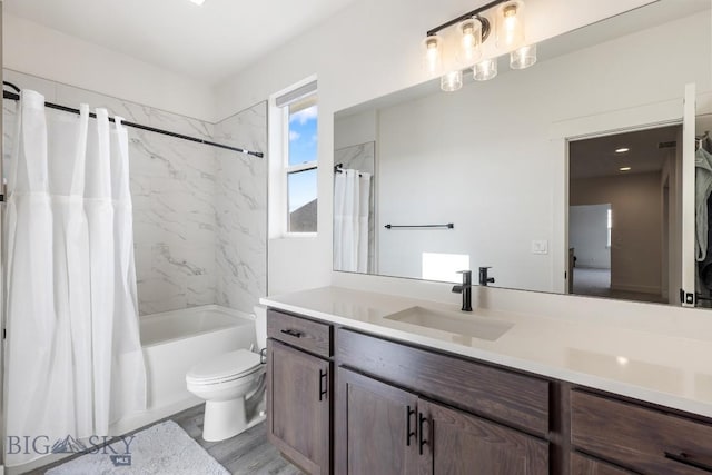 full bathroom with vanity, shower / bath combo, toilet, and wood finished floors
