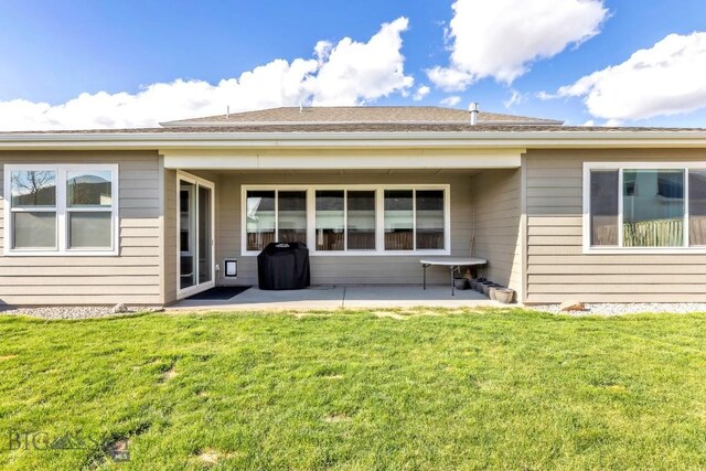 rear view of property featuring a lawn and a patio