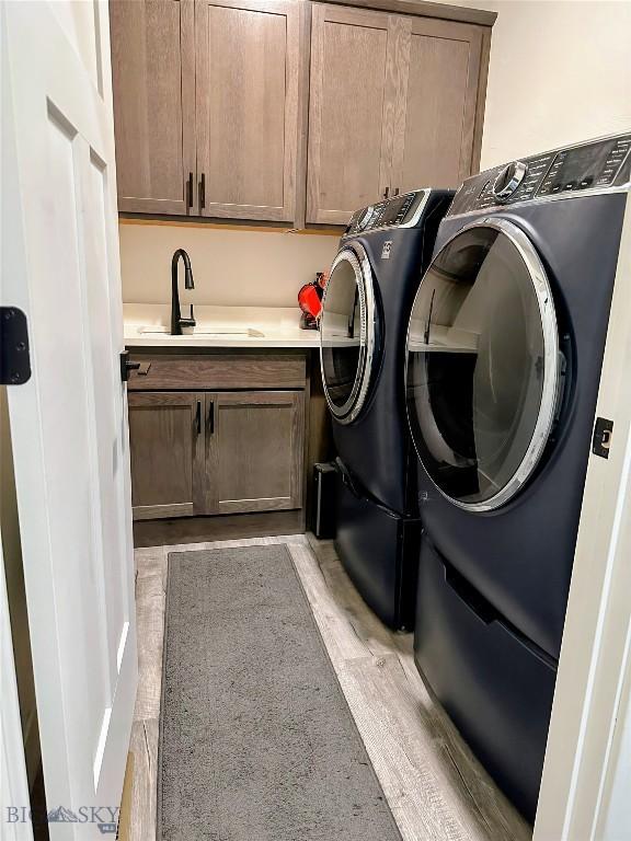 1508 Deadwood Loop, Belgrade, MT 59714 - laundry area with cabinet space, washer and clothes dryer, and light wood finished floors
