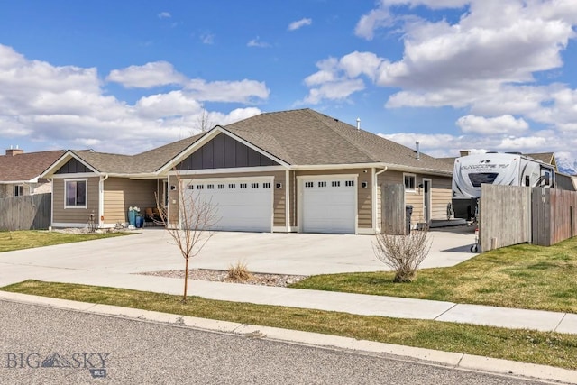 1708 Drummond Blvd, Belgrade, MT 59714 - view of front of house with board and batten siding, a garage, fence, and concrete driveway