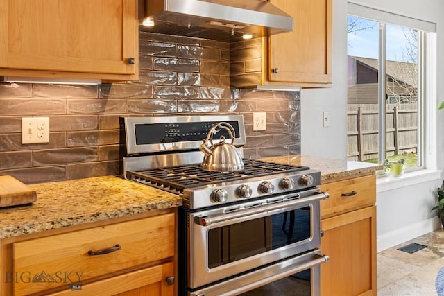 1708 Drummond Blvd, Belgrade, MT 59714 - kitchen featuring double oven range, wall chimney range hood, light stone countertops, decorative backsplash, and baseboards
