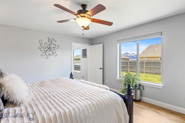 1708 Drummond Blvd, Belgrade, MT 59714 - bedroom with multiple windows, baseboards, light wood-style floors, and ceiling fan