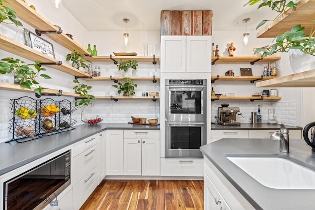 31 Haystack Dr, Bozeman, MT 59718 - kitchen featuring dark countertops, open shelves, a sink, black microwave, and double oven