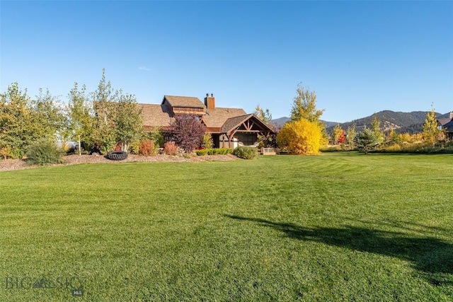 31 Haystack Dr, Bozeman, MT 59718 - view of front of house with a front lawn, a chimney, and a mountain view