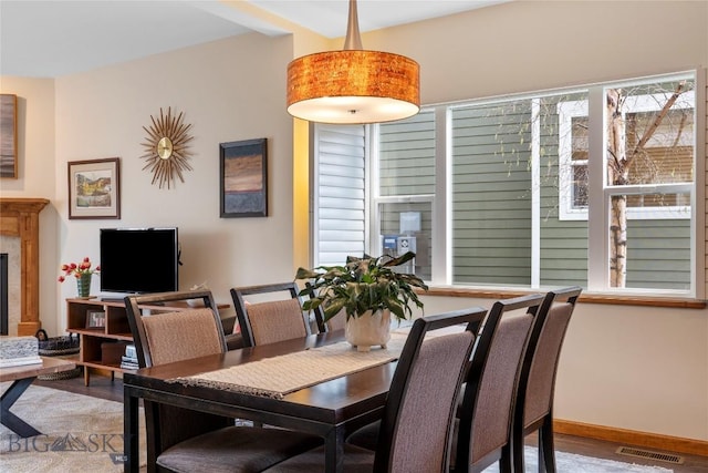 268 Pine Creek Dr, Bozeman, MT 59718 - dining room with a tile fireplace, wood finished floors, visible vents, and baseboards