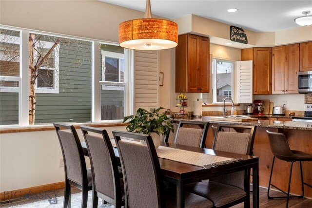 268 Pine Creek Dr, Bozeman, MT 59718 - kitchen featuring dark stone counters, a sink, brown cabinets, stainless steel appliances, and visible vents