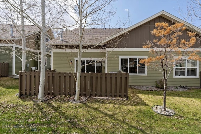 268 Pine Creek Dr, Bozeman, MT 59718 - back of property with board and batten siding, a lawn, fence, and roof with shingles