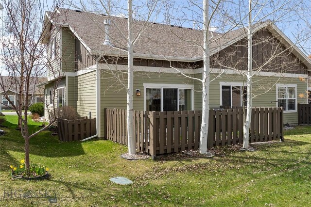 268 Pine Creek Dr, Bozeman, MT 59718 - rear view of house with a lawn, roof with shingles, and fence