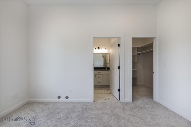 209 Pearl St, Ennis, MT 59729 - unfurnished bedroom with a walk in closet, light colored carpet, baseboards, and a closet