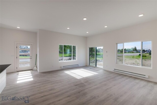 209 Pearl St, Ennis, MT 59729 - unfurnished living room with a baseboard radiator, healthy amount of natural light, light wood-type flooring, and recessed lighting
