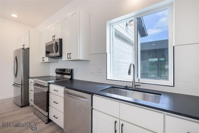 209 Pearl St, Ennis, MT 59729 - kitchen featuring appliances with stainless steel finishes, a sink, dark countertops, white cabinets, and recessed lighting