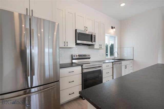 209 Pearl St, Ennis, MT 59729 - kitchen with stainless steel appliances, dark countertops, a sink, tasteful backsplash, and recessed lighting