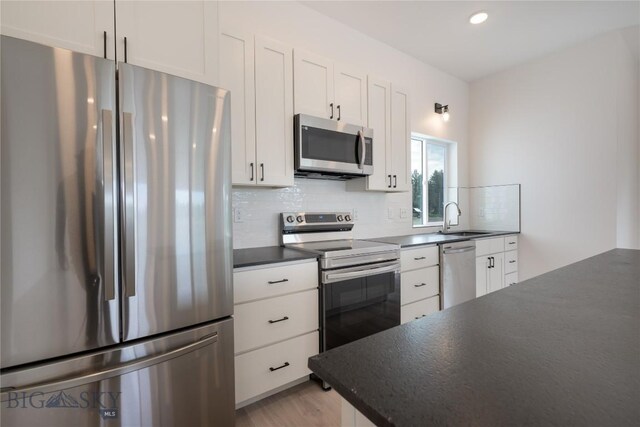 209 Pearl St, Ennis, MT 59729 - kitchen with appliances with stainless steel finishes, dark countertops, a sink, tasteful backsplash, and recessed lighting