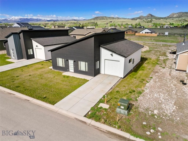 209 Pearl St, Ennis, MT 59729 - view of front of home with an attached garage, a mountain view, driveway, and a front lawn