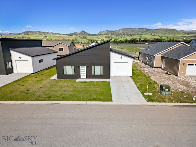 209 Pearl St, Ennis, MT 59729 - view of front of home with a mountain view, a front lawn, an outbuilding, a garage, and concrete driveway