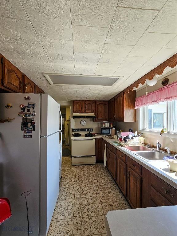 602 Harris, Big Timber, MT 59011 - kitchen featuring light floors, under cabinet range hood, light countertops, and white appliances
