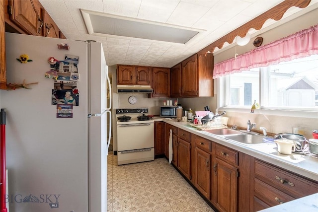 602 Harris, Big Timber, MT 59011 - kitchen with a sink, brown cabinetry, white appliances, light floors, and under cabinet range hood