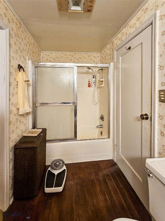 602 Harris, Big Timber, MT 59011 - full bath featuring shower / bath combination with glass door, toilet, wallpapered walls, crown molding, and hardwood / wood-style flooring