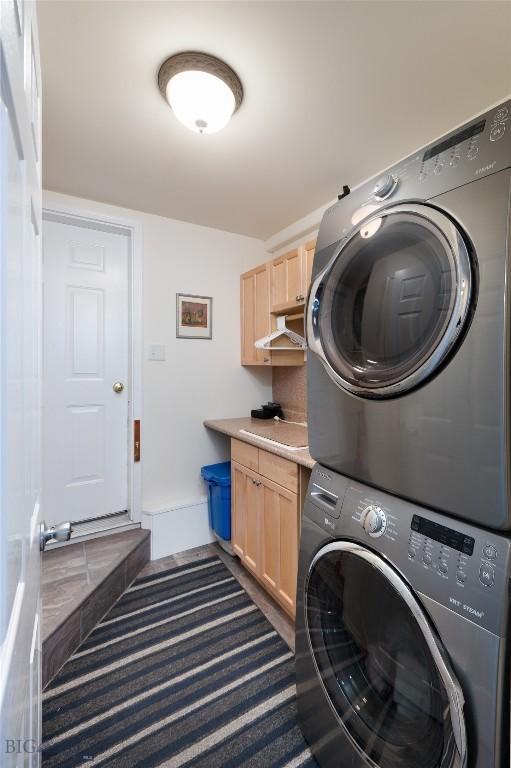 682 E River Rd, Pray, MT 59065 - washroom with stacked washing machine and dryer, cabinet space, and baseboards