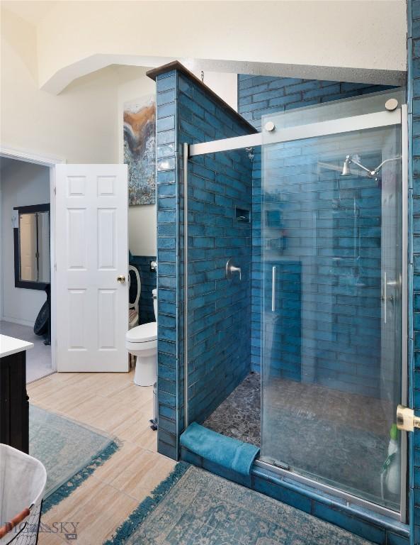 682 E River Rd, Pray, MT 59065 - bathroom with a stall shower, toilet, vanity, and wood finished floors
