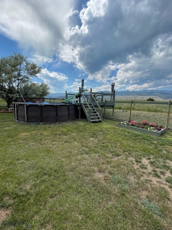 682 E River Rd, Pray, MT 59065 - view of green lawn with an outdoor pool and a wooden deck