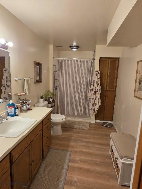 606 S Arizona, Dillon, MT 59725 - bathroom with curtained shower, wood finished floors, vanity, and toilet