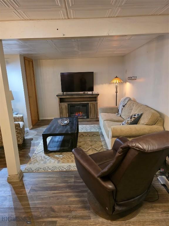 606 S Arizona, Dillon, MT 59725 - living area with wood finished floors, baseboards, a glass covered fireplace, and an ornate ceiling