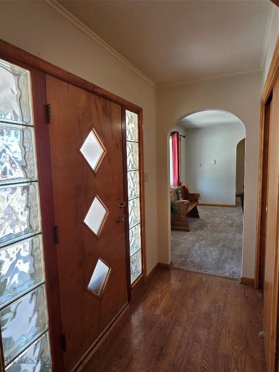 606 S Arizona, Dillon, MT 59725 - foyer featuring arched walkways, baseboards, wood finished floors, and crown molding