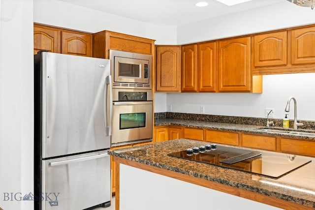 1413 Cherry Dr, Bozeman, MT 59715 - kitchen with stainless steel appliances, brown cabinets, dark stone countertops, and recessed lighting