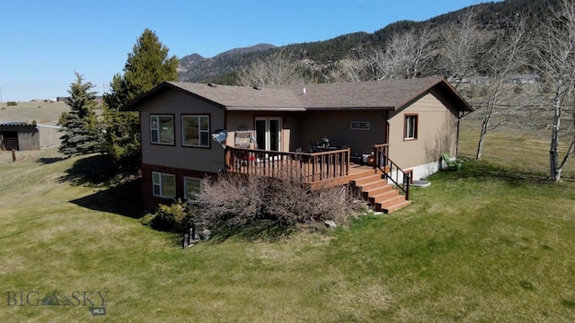 rear view of property featuring a lawn and a deck with mountain view