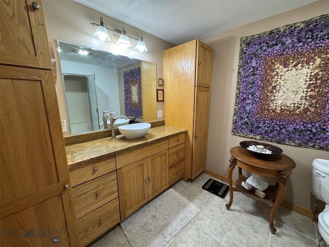 bathroom with tile patterned floors, vanity, toilet, and baseboards