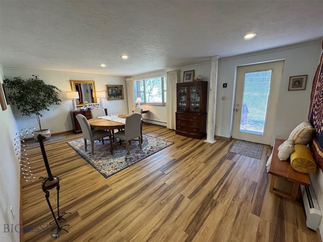 dining area with baseboard heating, baseboards, wood finished floors, and recessed lighting