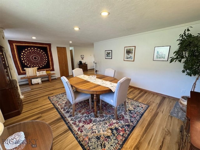 dining area with light wood-style flooring, a baseboard radiator, baseboards, recessed lighting, and ornamental molding
