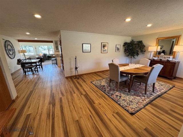 dining area featuring wood finished floors, crown molding, and recessed lighting