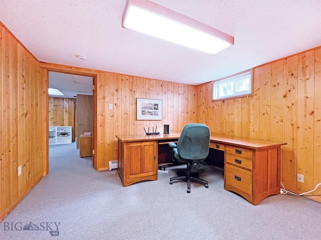 office space featuring baseboard heating, wood walls, and light carpet