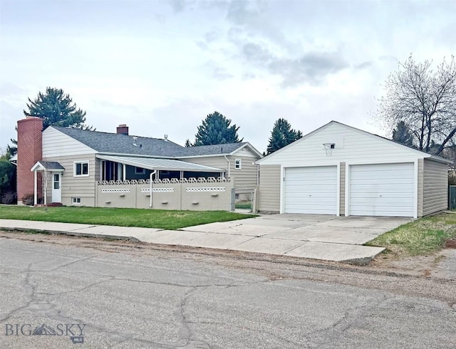 exterior space featuring an outdoor structure, a chimney, and a garage
