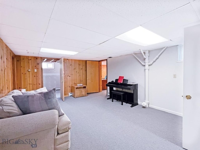 carpeted living room with wood walls and baseboards