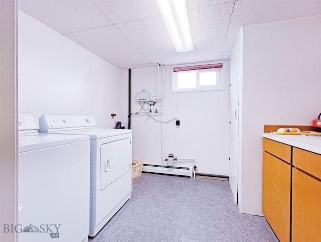 laundry area with cabinet space, a baseboard heating unit, and washing machine and dryer