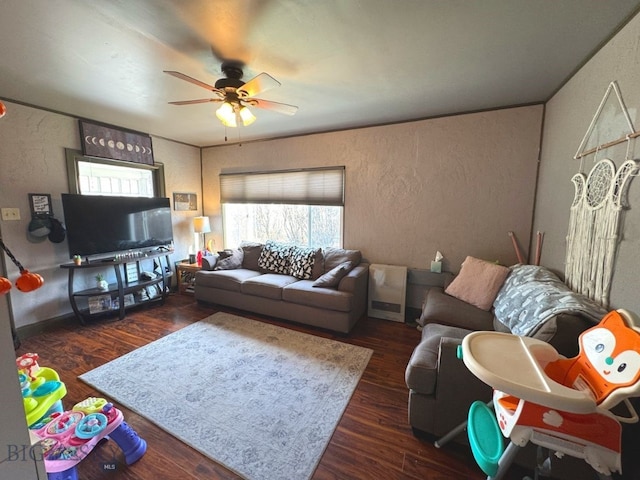 living room with wood finished floors, a textured wall, and a ceiling fan