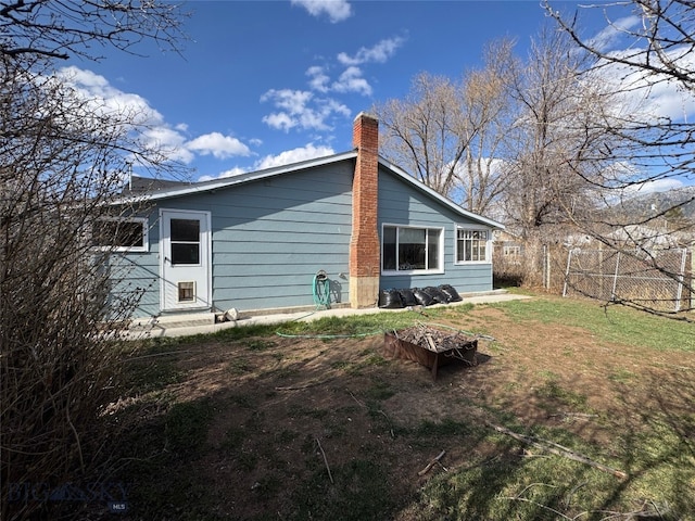 back of property featuring a chimney, fence, and entry steps