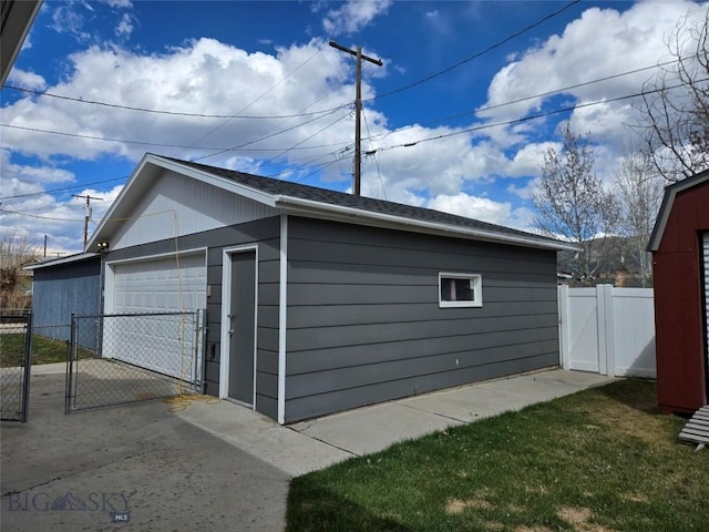 detached garage with fence and a gate