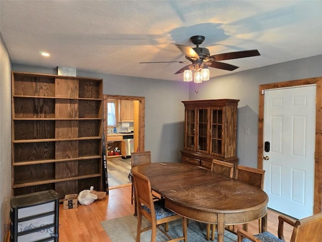 dining space with wood finished floors and ceiling fan