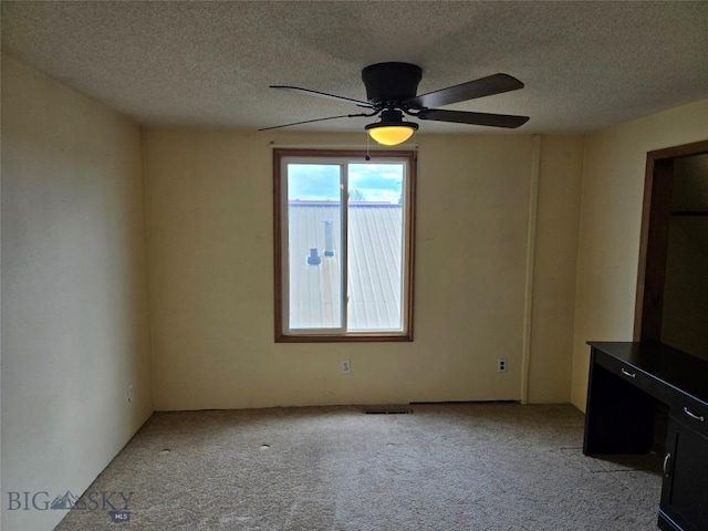 unfurnished living room with a textured ceiling, visible vents, and light carpet