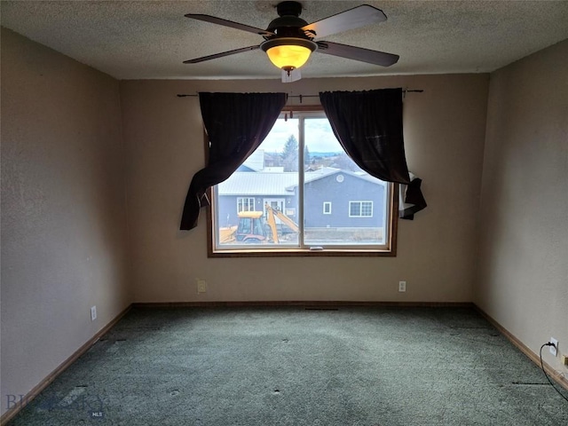 carpeted spare room with a textured ceiling, ceiling fan, and baseboards