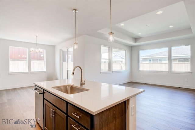 1520 Cyril Way, Belgrade, MT 59714 - kitchen with stainless steel dishwasher, light wood-style floors, open floor plan, light countertops, and decorative light fixtures